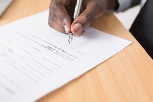 Diverse business leader, signing a contract with ballpoint pen in office setting, contract dispute, contract mediation
